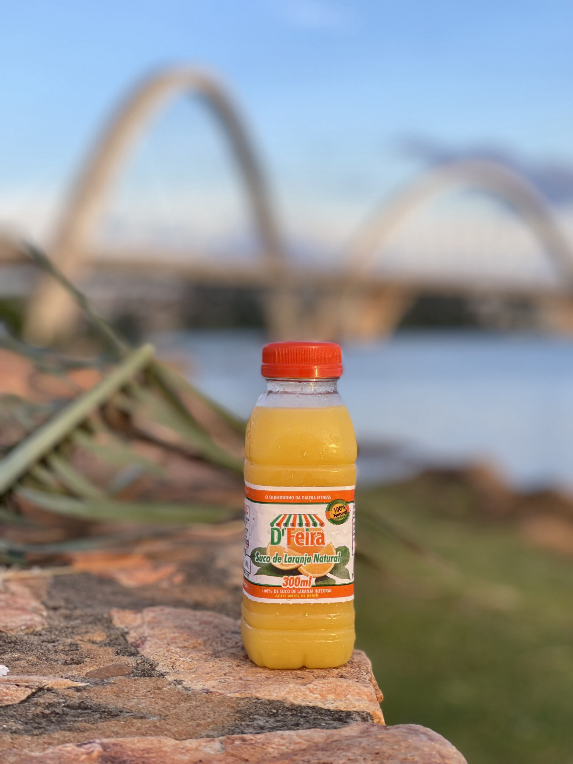 garrafa de suco de laranja em frente a ponde JK em Brasília